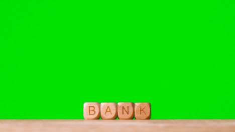 Business-Concept-Wooden-Letter-Cubes-Or-Dice-Spelling-Bank-Against-Green-Screen