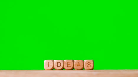 Business-Concept-Wooden-Letter-Cubes-Or-Dice-Spelling-Ideas-Against-Green-Screen