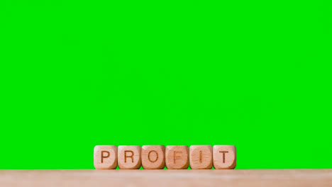 Business-Concept-Wooden-Letter-Cubes-Or-Dice-Spelling-Profit-Against-Green-Screen