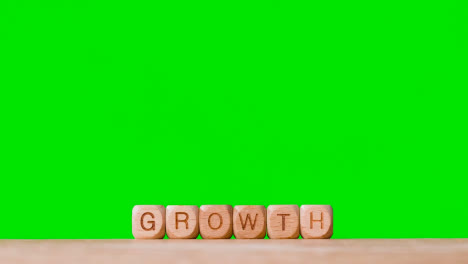 Geschäftskonzept-Holzbuchstabenwürfel-Oder-Würfel-Buchstabieren-Wachstum-Gegen-Grünen-Bildschirm