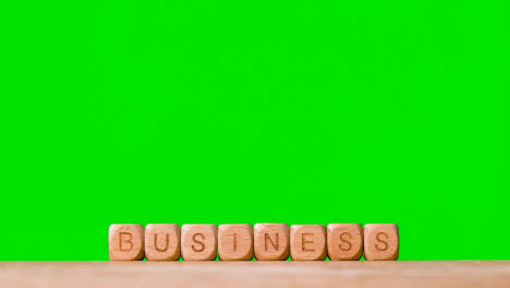 Business-Concept-Wooden-Letter-Cubes-Or-Dice-Spelling-Business-Against-Green-Screen