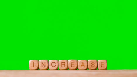 Business-Concept-Wooden-Letter-Cubes-Or-Dice-Spelling-Increase-Against-Green-Screen