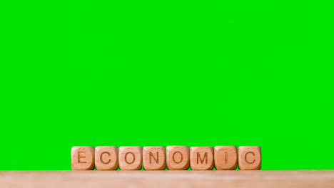 Concepto-De-Negocio-Cubos-De-Letras-De-Madera-O-Dados-Ortografía-Económica-Contra-Pantalla-Verde