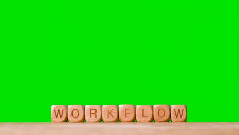 Business-Concept-Wooden-Letter-Cubes-Or-Dice-Spelling-Workflow-Against-Green-Screen