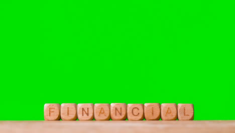 Business-Concept-Wooden-Letter-Cubes-Or-Dice-Spelling-Financial-Against-Green-Screen
