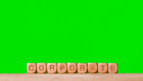 Geschäftskonzept-Holzbuchstabenwürfel-Oder-Würfel,-Die-Korporativ-Gegen-Grünen-Bildschirm-Schreiben
