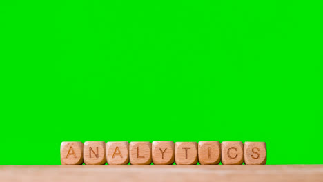 Business-Concept-Wooden-Letter-Cubes-Or-Dice-Spelling-Analytics-Against-Green-Screen