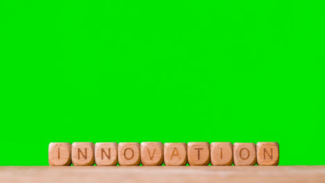 Concepto-De-Negocio-Cubos-De-Letras-De-Madera-O-Innovación-Ortográfica-De-Dados-Contra-Pantalla-Verde