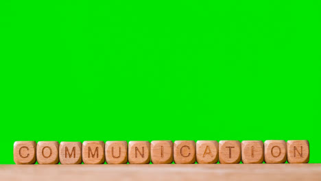 Business-Concept-Wooden-Letter-Cubes-Or-Dice-Spelling-Communication-Against-Green-Screen