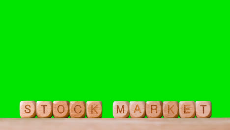 Business-Concept-Wooden-Letter-Cubes-Or-Dice-Spelling-Stock-Market-Against-Green-Screen