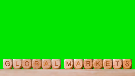Business-Concept-Wooden-Letter-Cubes-Or-Dice-Spelling-Global-Markets-Against-Green-Screen