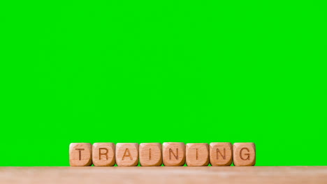 Education-Concept-With-Wooden-Letter-Cubes-Or-Dice-Spelling-Training-Against-Green-Screen-Background