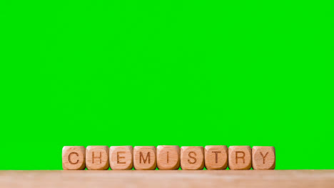 Education-Concept-With-Wooden-Letter-Cubes-Or-Dice-Spelling-Chemistry-Against-Green-Screen-Background