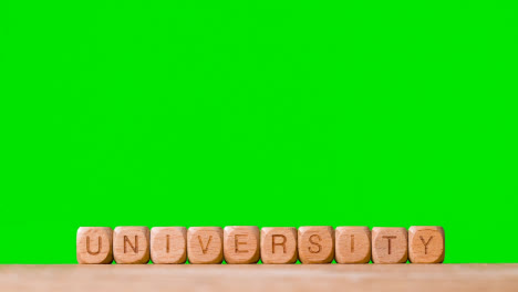 Education-Concept-With-Wooden-Letter-Cubes-Or-Dice-Spelling-University-Against-Green-Screen