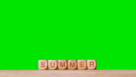 Konzept-Mit-Hölzernen-Buchstabenwürfeln-Oder-Würfeln,-Die-Sommer-Vor-Grünem-Hintergrund-Buchstabieren