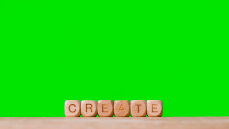 Concept-With-Wooden-Letter-Cubes-Or-Dice-Spelling-Create-Against-Green-Screen