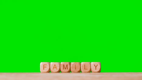 Konzept-Mit-Holzbuchstabenwürfeln-Oder-Würfeln,-Die-Familie-Gegen-Grünen-Bildschirm-Buchstabieren