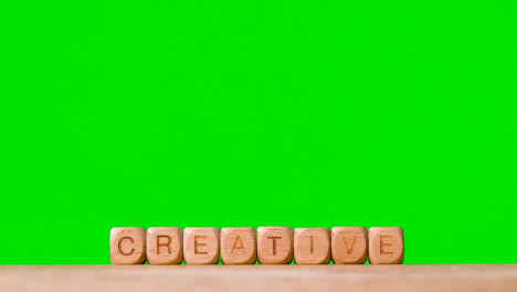 Konzept-Mit-Holzbuchstabenwürfeln-Oder-Würfeln,-Die-Kreativ-Gegen-Grünen-Bildschirm-Buchstabieren