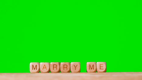 Konzept-Mit-Hölzernen-Buchstabenwürfeln-Oder-Würfelrechtschreibung-Heirate-Mich-Vor-Grünem-Hintergrund