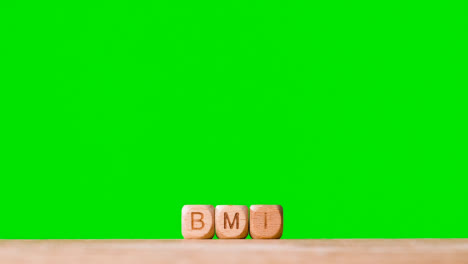 Medizinisches-Konzept-Mit-Holzbuchstabenwürfeln-Oder-Würfeln,-Die-Bmi-Vor-Grünem-Hintergrund-Buchstabieren