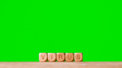 Medizinisches-Konzept-Mit-Holzbuchstabenwürfeln-Oder-Würfelbuchstabiervirus-Vor-Grünem-Hintergrund