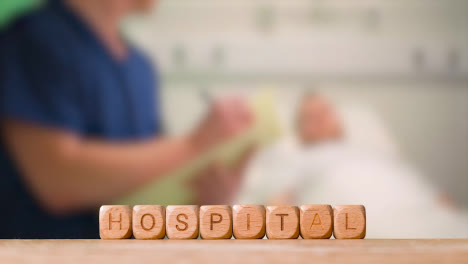 Medizinisches-Konzept-Mit-Holzbuchstabenwürfeln-Oder-Würfeln,-Die-Krankenhaus-Vor-Dem-Hintergrund-Der-Krankenschwester-Sprechen,-Die-Mit-Dem-Patienten-Im-Krankenhausbett-Spricht