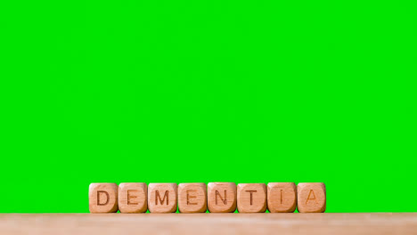 Medical-Concept-With-Wooden-Letter-Cubes-Or-Dice-Spelling-Dementia-Against-Green-Screen
