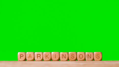 Medizinisches-Konzept-Mit-Holzbuchstabenwürfeln-Oder-Würfeln,-Die-Parkinson-Gegen-Grünen-Bildschirm-Buchstabieren