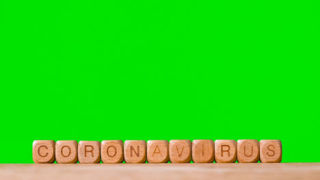 Medical-Concept-With-Wooden-Letter-Cubes-Or-Dice-Spelling-Coronavirus-Against-Green-Screen-Background