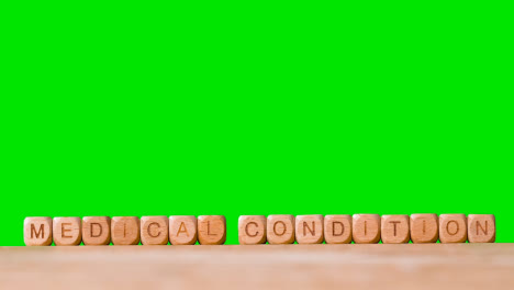 Medical-Concept-With-Wooden-Letter-Cubes-Or-Dice-Spelling-Medical-Condition-Against-Green-Screen-Background