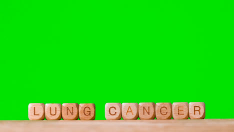 Medical-Concept-With-Wooden-Letter-Cubes-Or-Dice-Spelling-Lung-Cancer-Against-Green-Screen-Background