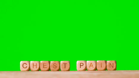 Medical-Concept-With-Wooden-Letter-Cubes-Or-Dice-Spelling-Chest-Pain-Against-Green-Screen