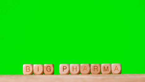 Medizinisches-Konzept-Mit-Holzbuchstabenwürfeln-Oder-Würfeln,-Die-Big-Pharma-Gegen-Grünen-Bildschirm-Buchstabieren