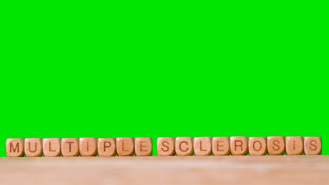 Medical-Concept-With-Wooden-Letter-Cubes-Or-Dice-Spelling-Multiple-Sclerosis-Against-Green-Screen-Background