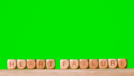 Medical-Concept-With-Wooden-Letter-Cubes-Or-Dice-Spelling-Heart-Failure-Against-Green-Screen-Background
