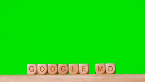 Medizinisches-Konzept-Mit-Holzbuchstabenwürfeln-Oder-Würfeln,-Die-Google-Md-Vor-Grünem-Hintergrund-Buchstabieren