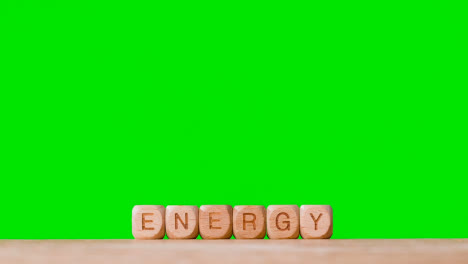 Konzept-Mit-Hölzernen-Buchstabenwürfeln-Oder-Würfeln,-Die-Energie-Vor-Grünem-Hintergrund-Buchstabieren