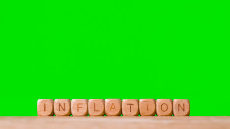 Concept-With-Wooden-Letter-Cubes-Or-Dice-Spelling-Inflation-Against-Green-Screen-Background