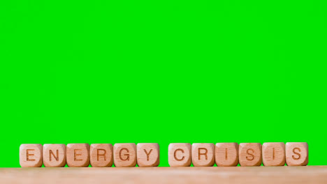 Konzept-Mit-Hölzernen-Buchstabenwürfeln-Oder-Würfeln,-Die-Energiekrise-Vor-Grünem-Hintergrund-Buchstabieren