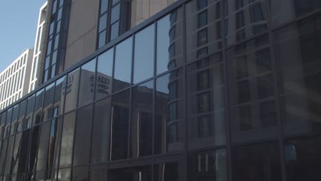 Außenansicht-Des-Bbc-Wales-gebäudes-Im-Stadtzentrum-Von-Cardiff,-Das-Sich-Im-Glas-Moderner-Bürogebäude-Widerspiegelt