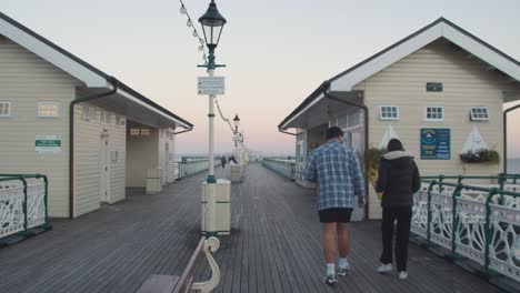 Menschen,-Die-In-Der-Abenddämmerung-Am-Penarth-Pier-In-Wales-Spazieren-1