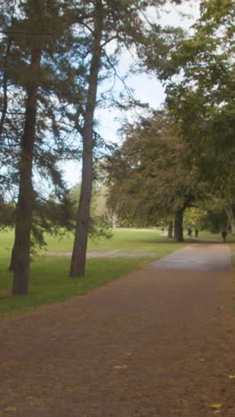 Vertical-Video-Autumn-View-Of-Bute-Park-In-Cardiff-Wales-With-Cyclists