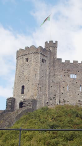 Vertikales-Video-Der-Walisischen-Flagge,-Die-Von-Cardiff-Castle-Gegen-Den-Blauen-Himmel-Weht-1