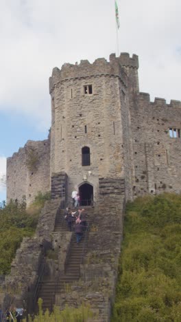 Vertical-Video-Of-People-Climbing-Steps-Up-To-Cardiff-Castle-Against-Blue-Sky