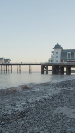 Vertical-Video-Of-Penarth-Pier-And-Pavilion-Theatre-In-Wales-At-Dusk-From-Beach