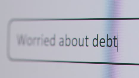 Close-Up-Of-Screen-With-Person-Typing-Worried-About-Debt-Into-Computer-Search-Engine