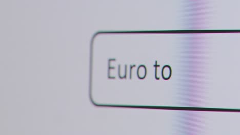 Primer-Plano-De-La-Pantalla-Con-Una-Persona-Escribiendo-Euro-A-Dólar-Estadounidense-En-El-Motor-De-Búsqueda-De-La-Computadora