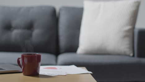 Laptop-On-Table-At-Home-Covered-With-Bills-In-Cost-Of-Living-Crisis-And-Hot-Drink