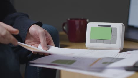 Person-Mit-Heißem-Getränk-Sitzt-Zu-Hause-Auf-Dem-Sofa-Mit-Laptop-energierechnungen-Und-Smart-Meter-4