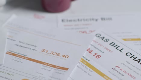 Close-Up-Of-Table-At-Home-With-Overdue-US-Energy-Bills-And-Smart-Meter